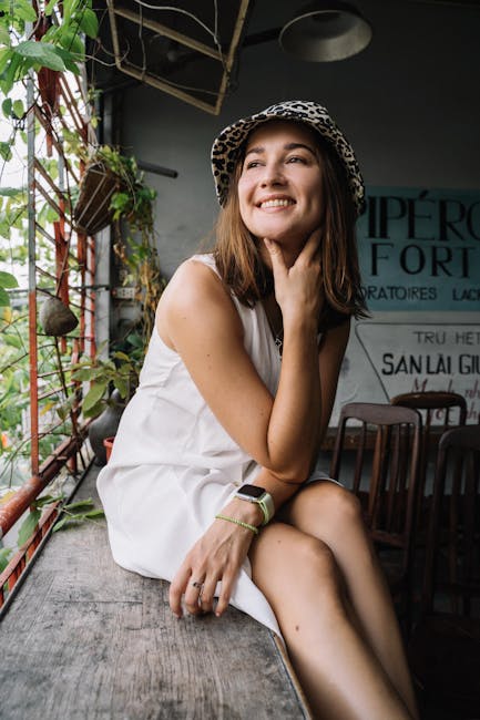 Donna sorridente con cappello leopardato in ambiente luminoso e accogliente, atmosfera positiva e rilassante.