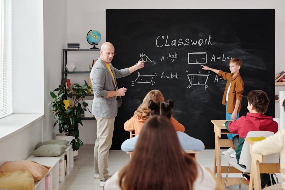 Lezione di matematica primaria interattiva: insegnante e alunno spiegano formule geometriche alla lavagna per un apprendimento coinvolgente.