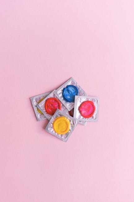 Preservativi colorati su sfondo rosa: salute sessuale e prevenzione per i giovani, tema Safer Internet Day e tutela minori online.