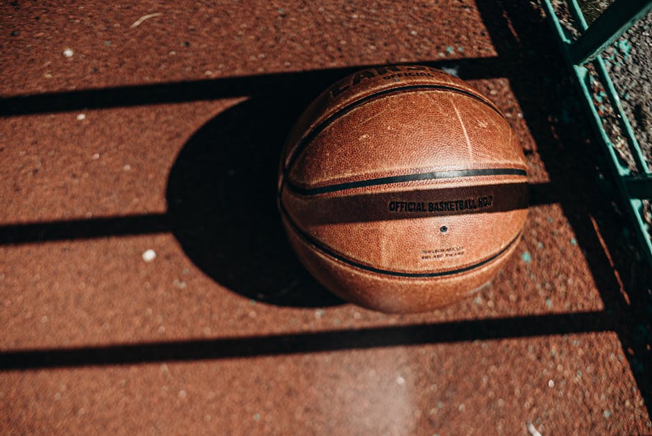 Pallone da basket in ombra su campo: metafora visiva per crediti e debiti formativi nel percorso educativo