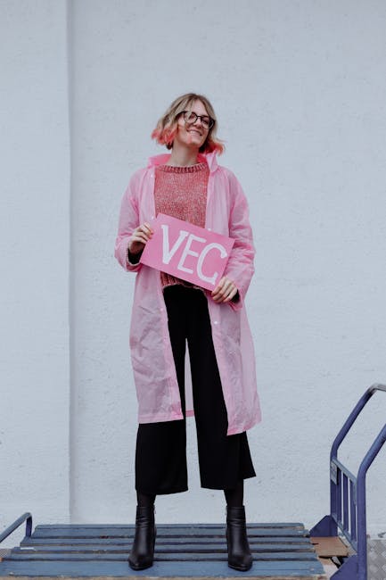 Ragazza sorridente con impermeabile rosa che tiene cartello VEC, download sicuri su 123dl, piattaforma facile e veloce.