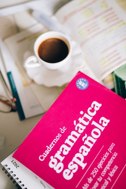 Libro di grammatica spagnola su scrivania con caffè, focus su nuove Indicazioni Nazionali 2026 e importanza delle lingue straniere