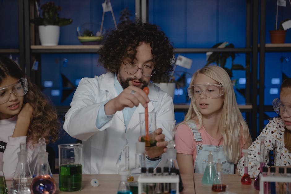 Insegnante di scienze che dimostra un esperimento a studenti con occhiali protettivi, esempio di metodo didattico innovativo per un apprendimento efficace.
