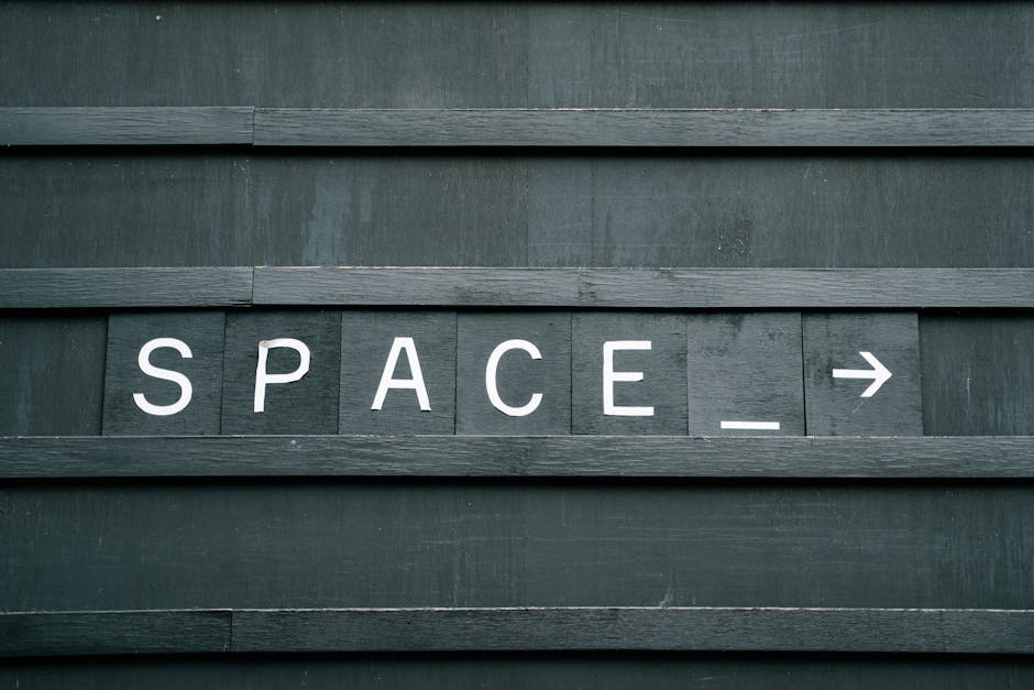 La parola SPACE seguita da una freccia su una bacheca di legno, metafora dello spazio mancante prima dell'apostrofo.