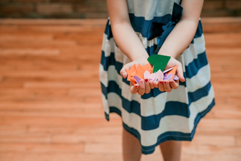Bambina con origami colorati nelle mani, attività creativa per stimolare l'immaginazione e la manualità nei bambini.