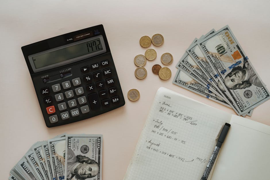 Calcolatrice, monete, banconote e quaderno con calcoli per la gestione delle finanze e tassi di interesse