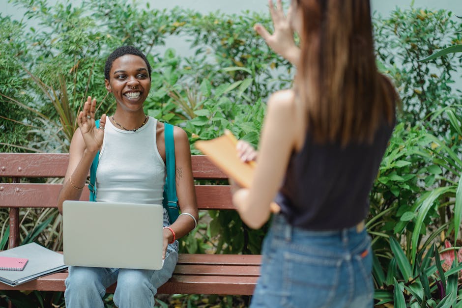 Studentessa saluta sorridendo con laptop in un contesto scolastico, allusione a scherzo pericoloso con candeggina e malore a scuola