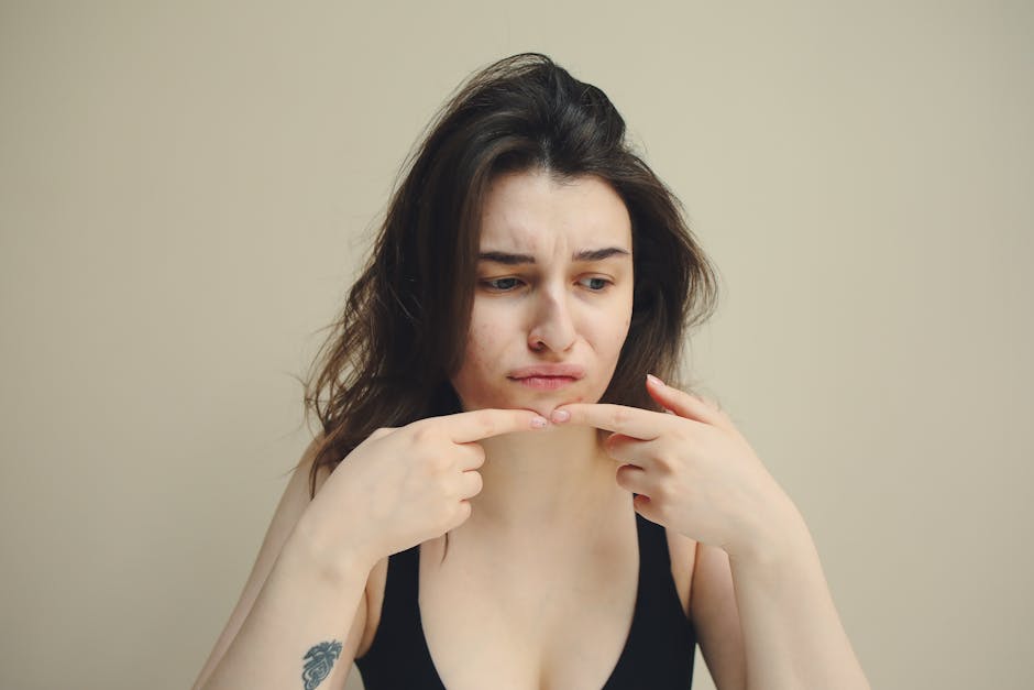 Giovane donna con espressione preoccupata che si tocca il mento, simbolo di disagio e potenziale indifferenza emotiva.