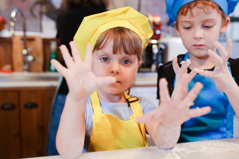 Bambini felici con mani sporche di farina durante laboratorio di cucina per bambini. Creatività e apprendimento in cucina.