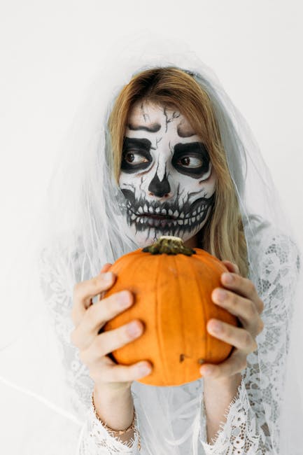 Ragazza con trucco da scheletro e velo tiene zucca di Halloween, pronta per festeggiare le Romanae Disputationes con un tocco macabro