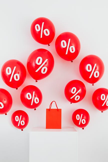 Palloncini rossi con simbolo percentuale e borsa della spesa rossa: visualizzazione del calcolo dello sconto e delle offerte speciali.