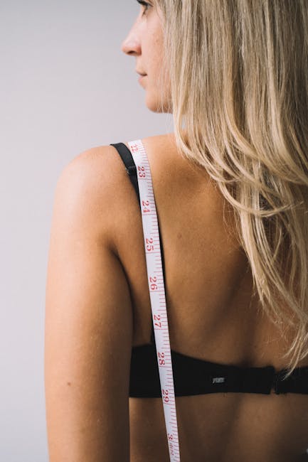 Donna che misura la circonferenza del braccio con un metro per monitorare i cambiamenti di peso e salute, legati a microgrammi e milligrammi.