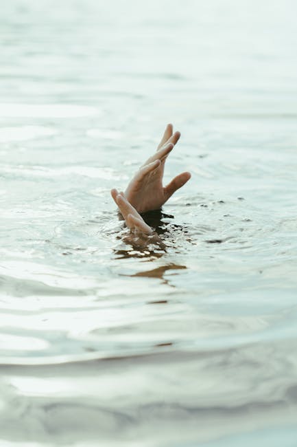 Mani che emergono dall'acqua: metafora di difficoltà economiche e ricerca di soluzioni per superare le sfide attuali