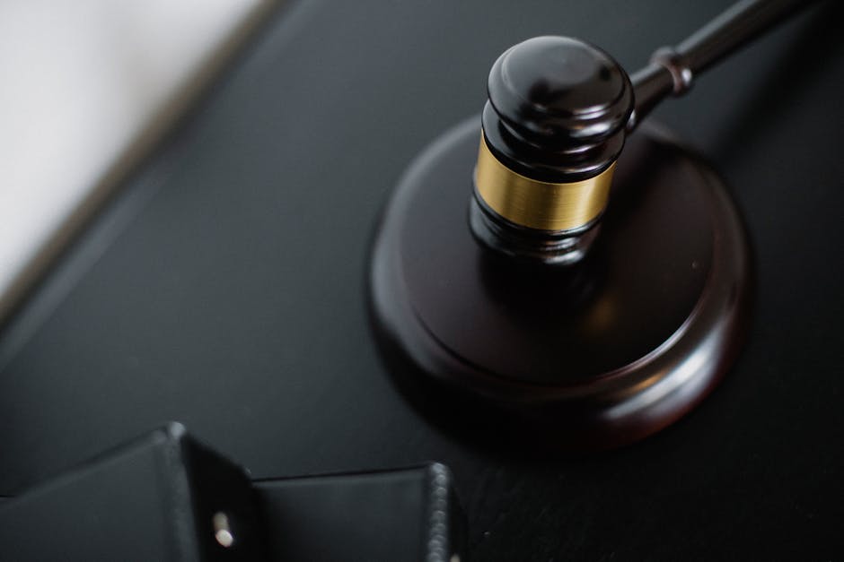 Martelletto del giudice su tavolo nero, simbolo di giustizia e legalità nel caso di bullismo in memoria di Leonardo Calcina