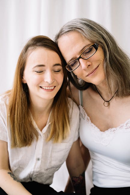 Due donne sorridenti si appoggiano l'una all'altra, simbolo di affetto e accettazione in relazioni autentiche e durature.