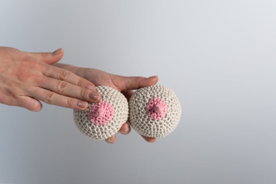Mani che tengono modelli di seni in maglia per educazione alla prevenzione del bullismo e body shaming durante gli Stati Generali