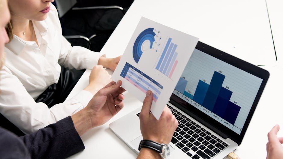 Analisi di mercato: team aziendale esamina grafici e dati su laptop e report cartaceo per strategie vincenti e successo aziendale