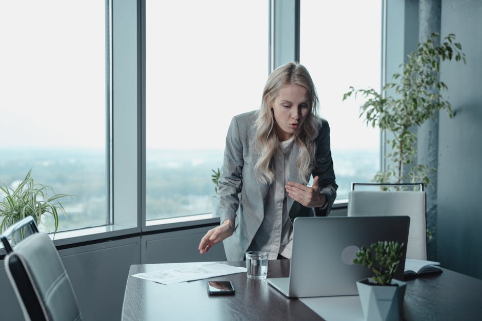 Donna stressata che parla al laptop, strategie di gestione dello stress per studenti, ambiente di lavoro moderno e luminoso.