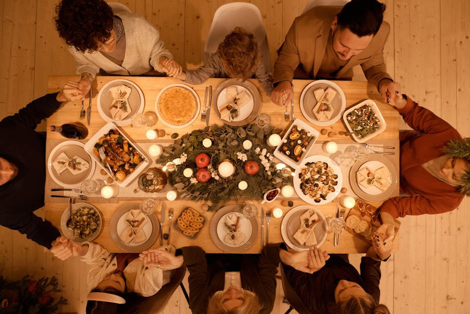 Famiglia riunita a tavola durante le festività natalizie, mani giunte, simbolo di unione e condivisione, in contrasto con il sovraffollamento delle aule.