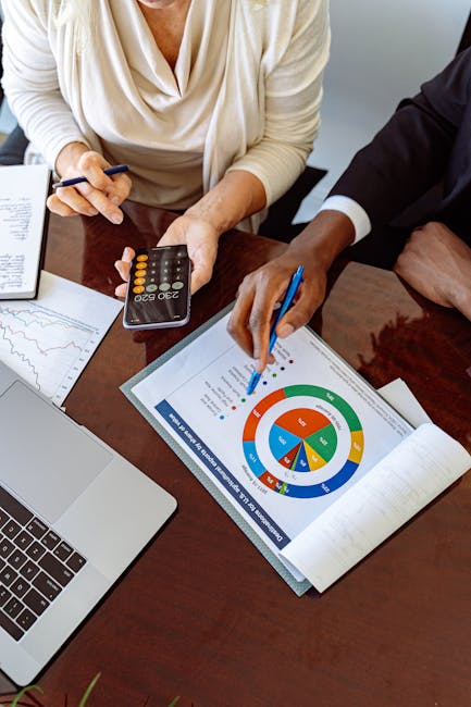 Analisi dati finanziari e politica monetaria: team al lavoro su grafici e calcolatrice per strategie di banche centrali.