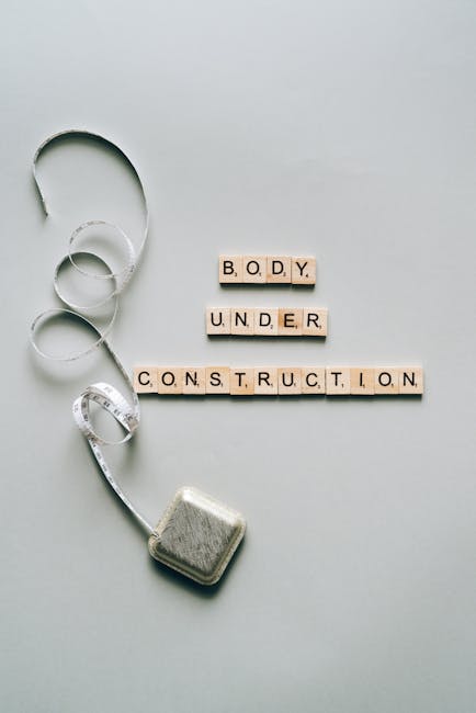 Corpo in costruzione: metafora interdisciplinare per il progresso, con metro da sarta e lettere che formano la frase Body Under Construction.