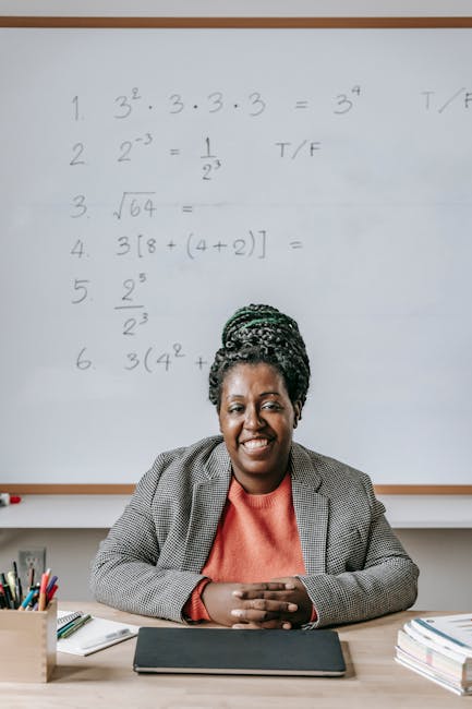 Docente sorridente davanti a lavagna con esercizi di matematica, corsi sostegno INDIRE per docenti con titolo estero