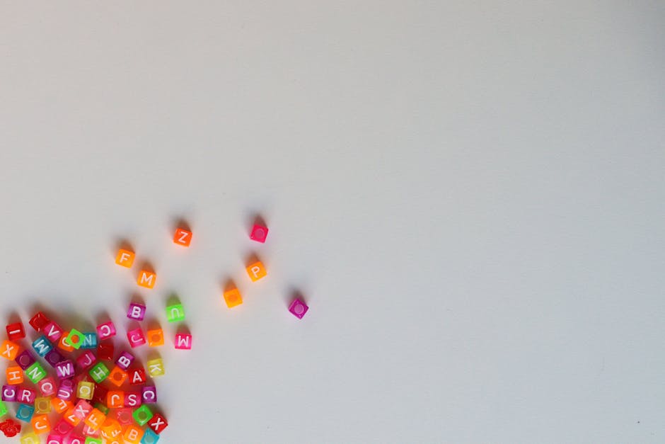 Cubetti colorati con lettere sparse su sfondo bianco, metafora di personalizzazione didattica e inclusione scolastica nel PEI