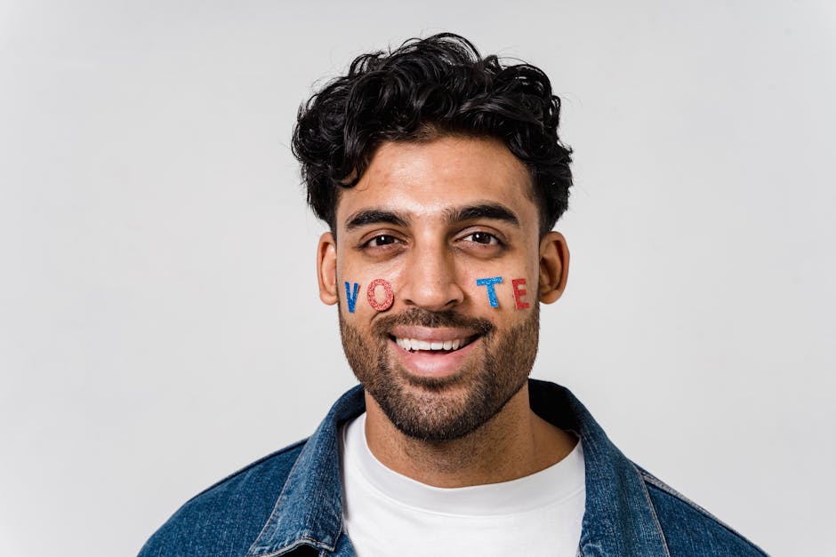 Giovane sorridente con la scritta VOTE sul viso, simbolo di partecipazione attiva e impegno civico nei progetti di cittadinanza.