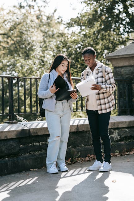 Due studenti universitari discutono dei documenti per l'iscrizione ai corsi serali 2025/26 per adulti e lavoratori.
