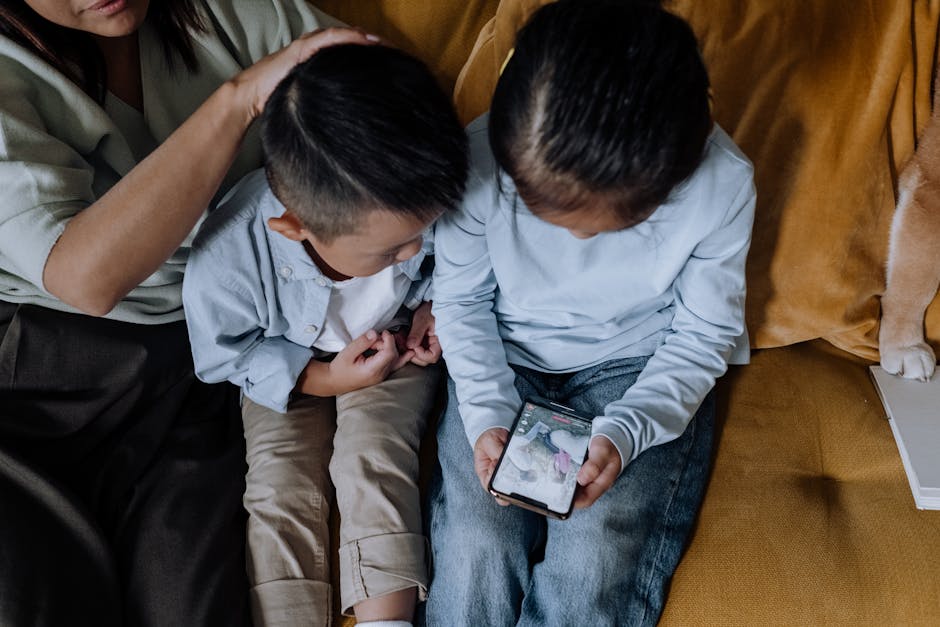 Due bambini guardano uno smartphone con la supervisione di un adulto, tema salute mentale e tecnoferenza nell'infanzia.
