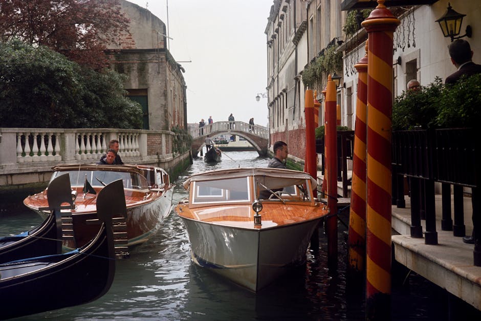 Canale veneziano con taxi acquei e gondole, simbolo di scambio culturale per assistenti di italiano all'estero. Venezia, Italia.