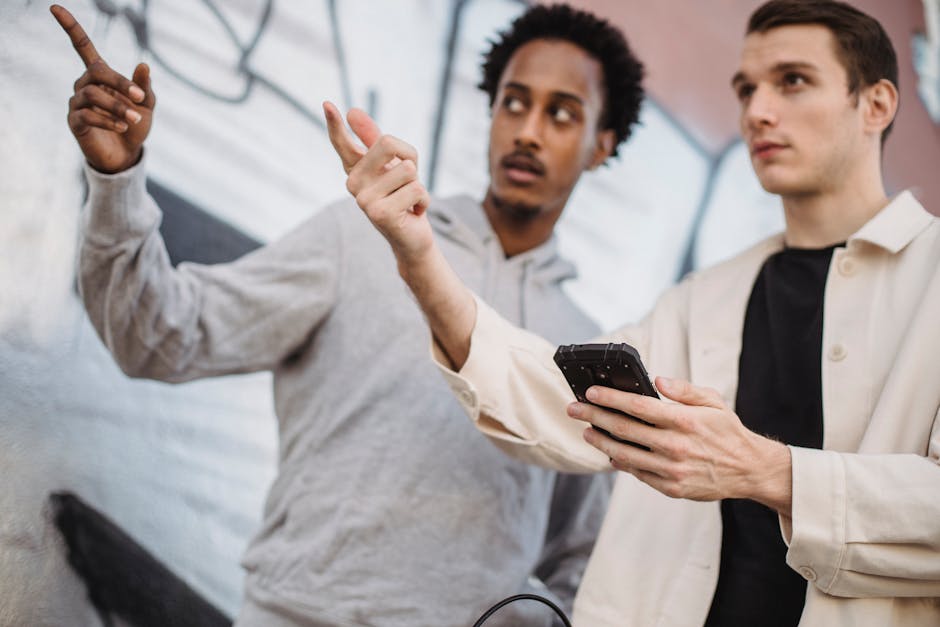 Due amici discutono guardando un muro, uno con smartphone, riflettendo sull'uso critico delle informazioni online e social media.