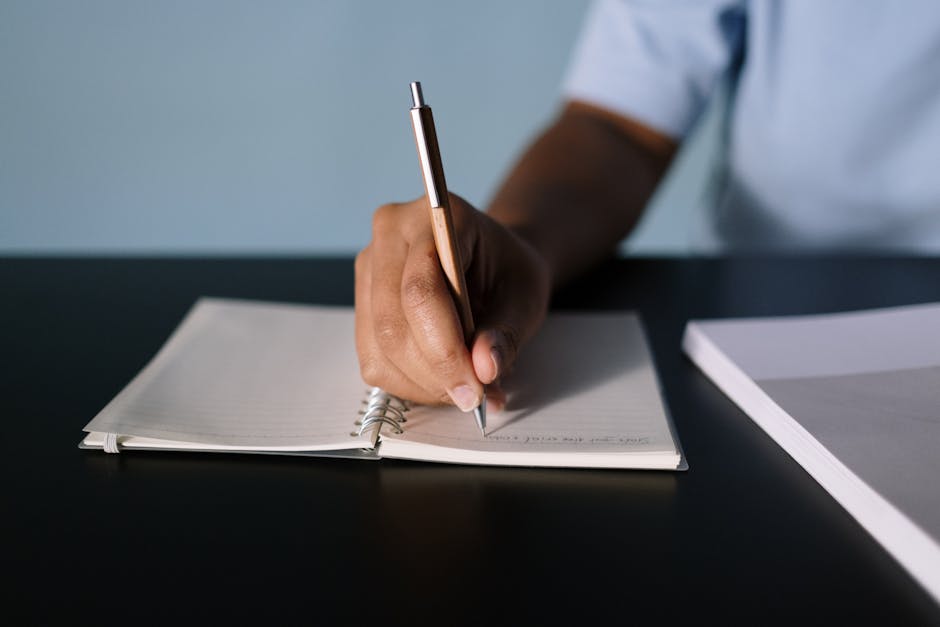 Persona che prende appunti su un quaderno, simbolo di riflessione sull'istruzione e analisi del sistema scolastico italiano.