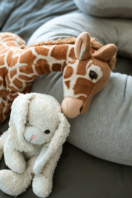 Peluche di giraffa e coniglio su cuscino: metafora della vulnerabilità infantile e della necessità di protezione legale