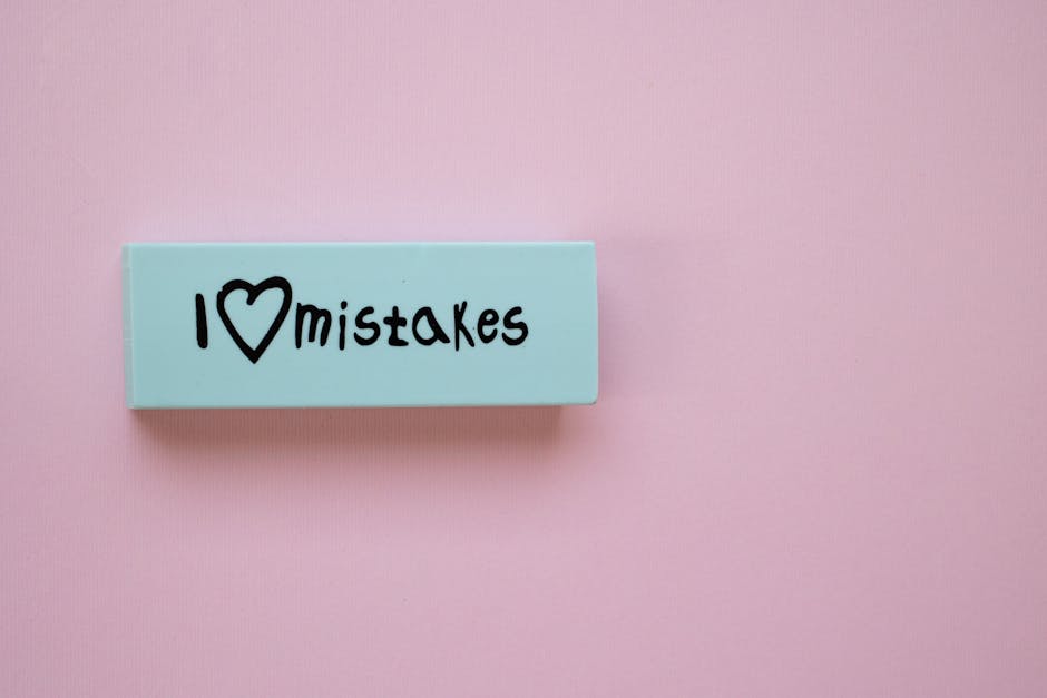 Blocco azzurro con scritta 'I love mistakes' su sfondo rosa, metafora errori nel servizio GPS 2026 e possibilità di correzione.