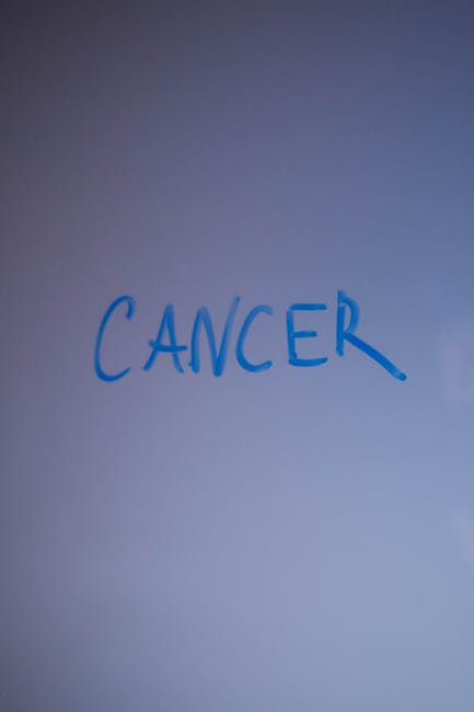 Scritta CANCER su sfondo bianco, metafora di malattie genetiche come la Malattia di Huntington e la ricerca di cure e trattamenti.