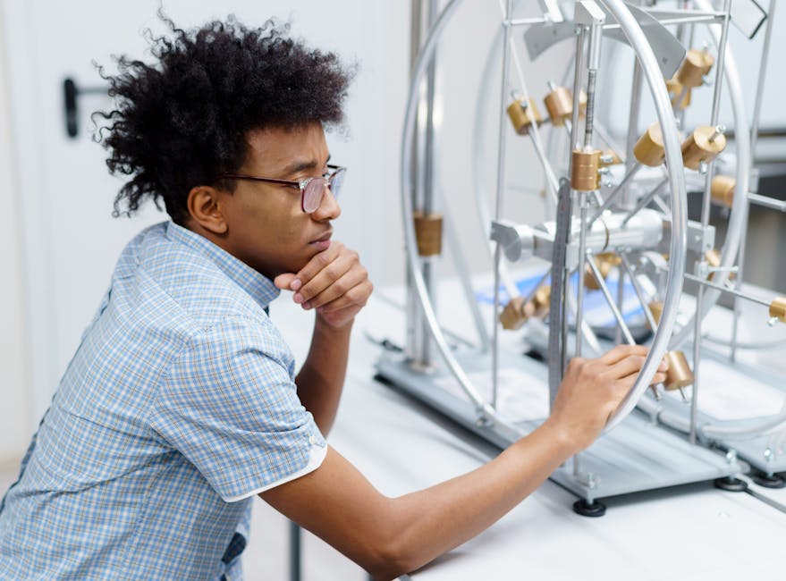 Studente esamina un complesso macchinario STEM, simbolo dell'innovazione e dei percorsi formativi TS Academy per il futuro dei giovani.
