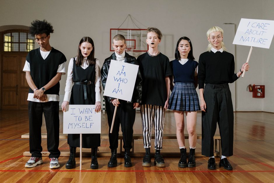 Giovani con cartelli che esprimono identità e autonomia, in relazione al film "Se domani non torno" e alla lotta contro la violenza di genere a scuola.