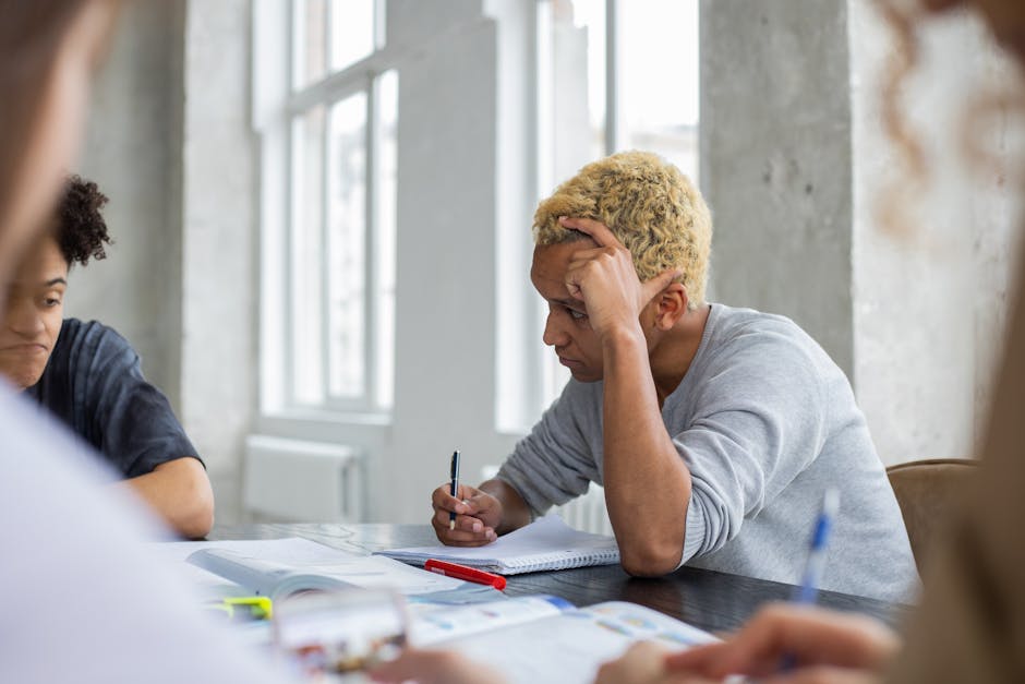 Studente pensieroso durante lo studio, difficoltà nella preparazione universitaria e rischio di abbandono degli studi in Italia