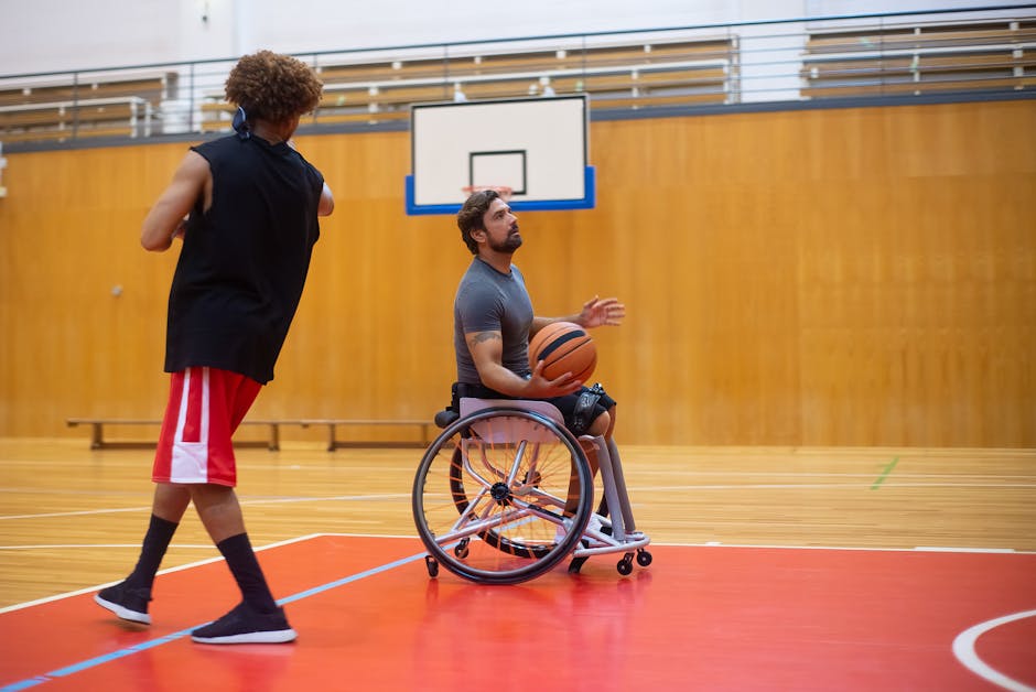 Uomo in sedia a rotelle gioca a basket con un compagno, esempio di inclusione e accessibilità nello sport e nei materiali formativi.