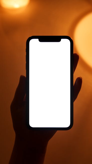 Smartphone con schermo bianco in mano, visualizzazione app per calcolo IVA e gestione fiscale per attività commerciali.