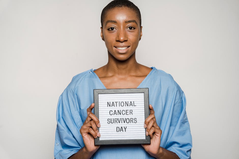 Donna sorridente con camice ospedaliero che celebra la Giornata Nazionale dei Sopravvissuti al Cancro, simbolo di resilienza e diritti dei lavoratori fragili