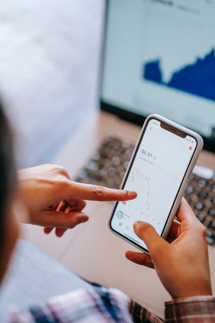 Persona che analizza grafici finanziari su smartphone, possibili investimenti con borse di studio 2025 e gestione fondi.