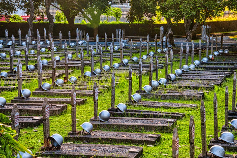 Cimitero di guerra con elmetti sulle tombe, simbolo della memoria storica e del rifiuto del totalitarismo, in ricordo delle vittime.