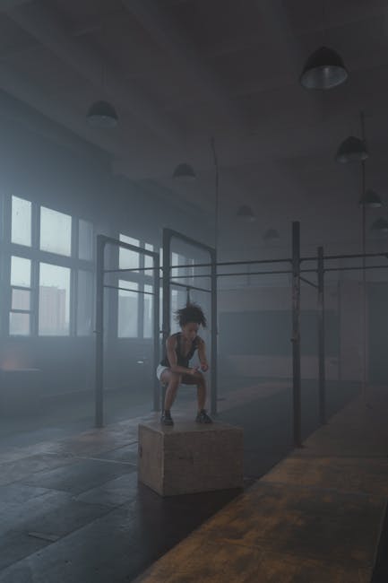 Donna afroamericana che si allena con box jump in palestra, simbolo di forza e resilienza contro la discriminazione razziale.