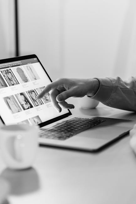 Scelta della risoluzione schermo: mano che interagisce con un laptop visualizzando immagini di abbigliamento online.