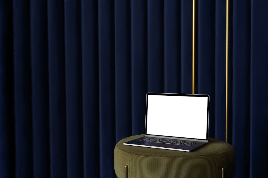 Laptop con schermo bianco su pouf verde oliva, sfondo blu scuro. Italia Semplice e digitalizzazione della PA.