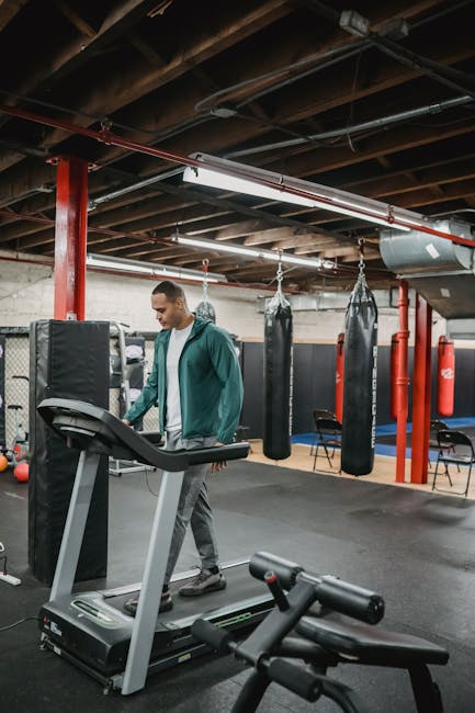 Uomo che cammina su tapis roulant in palestra, calcolo calorie bruciate con la camminata per il benessere fisico e la salute.