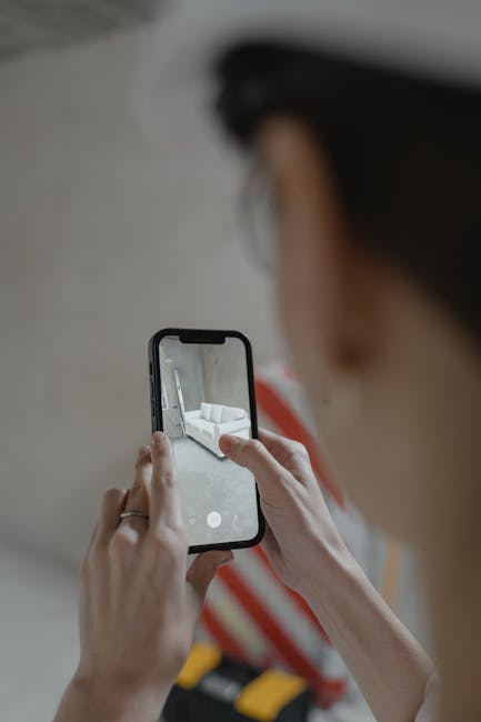 Persona che fotografa con smartphone un interno domestico per verifica, software per verifiche personalizzate in azione.