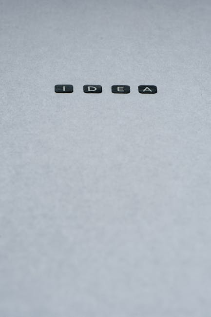 IDEA: Ispirazione Divina nell'Opera di Michelangelo Dettaglio della parola IDEA su sfondo grigio, metafora della creazione artistica di Michelangelo in Adamo ed Eva.